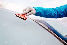 スクレーパーとフロントの車のフロント ガラスが凍結防止の女性。冬に車 の写真素材・画像素材. Image 68654730.